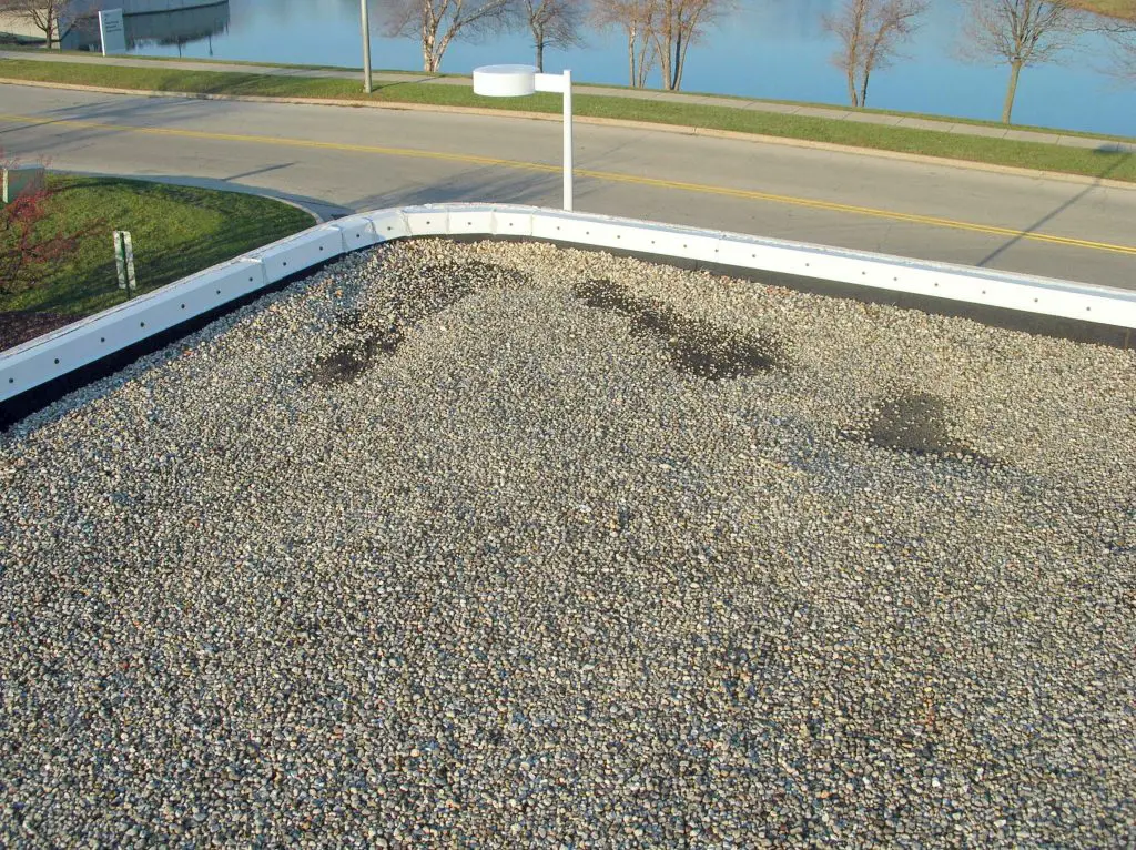 A common result of wind scour is the loss of aggregate surfacing on built-up roofs. More a maintenance issue than an urgent repair item, it should be addressed by coating the area or re-installing the aggregate in order to prevent the deterioration of the exposed asphalt due to long-term UV exposure.