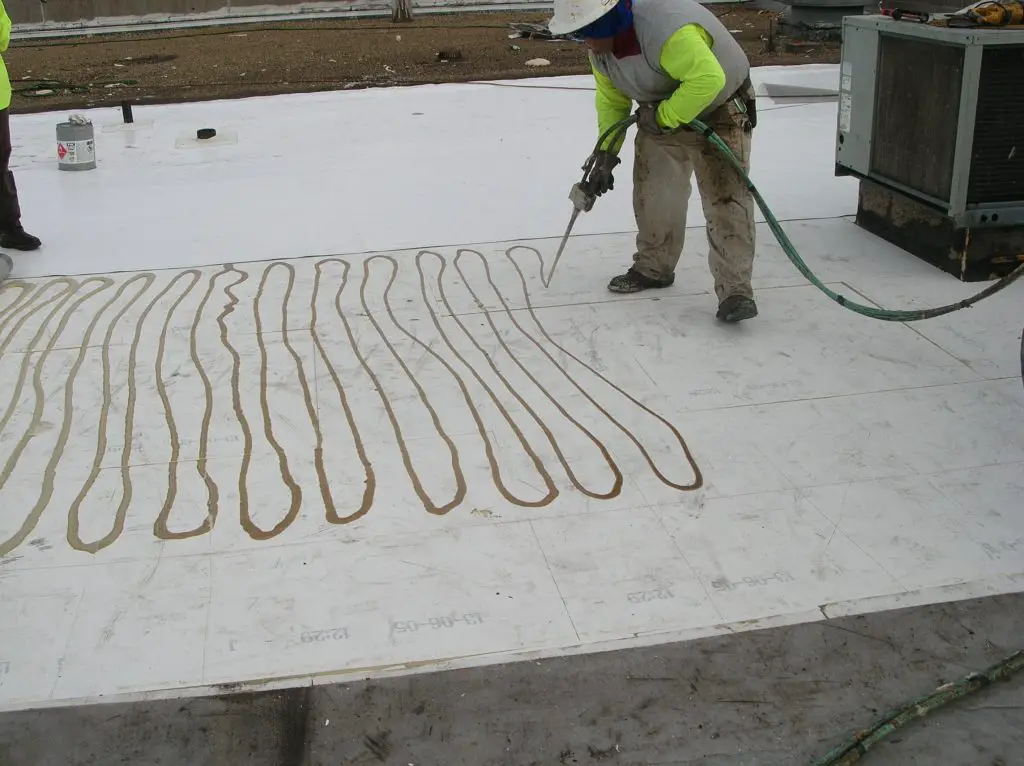 Installing a PVC field membrane sheet in polyurethane roofing adhesive
