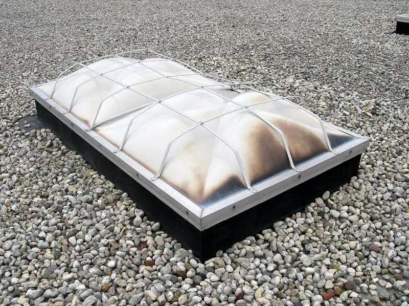 A 24-year-old melt-out type smoke vent. The discoloration is a result of material deterioration due to age and UV-exposure. The picture was taken in Chicago, and that is the south end of the smoke vent.