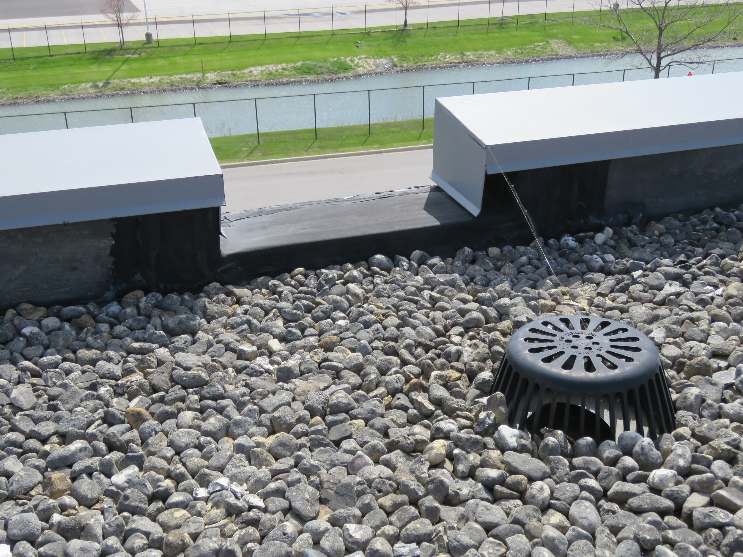 A channel-type overflow scupper on a ballasted EPDM roof