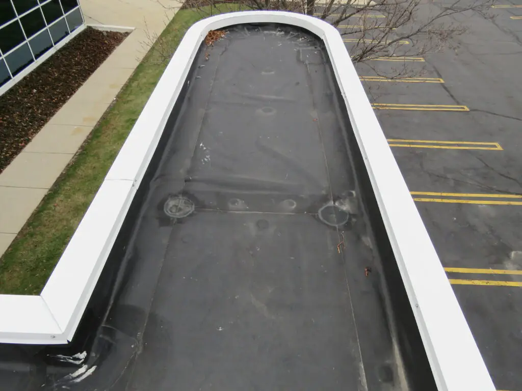 Coated steel coping used as edge metal to secure the perimeter of this EPDM roof membrane.