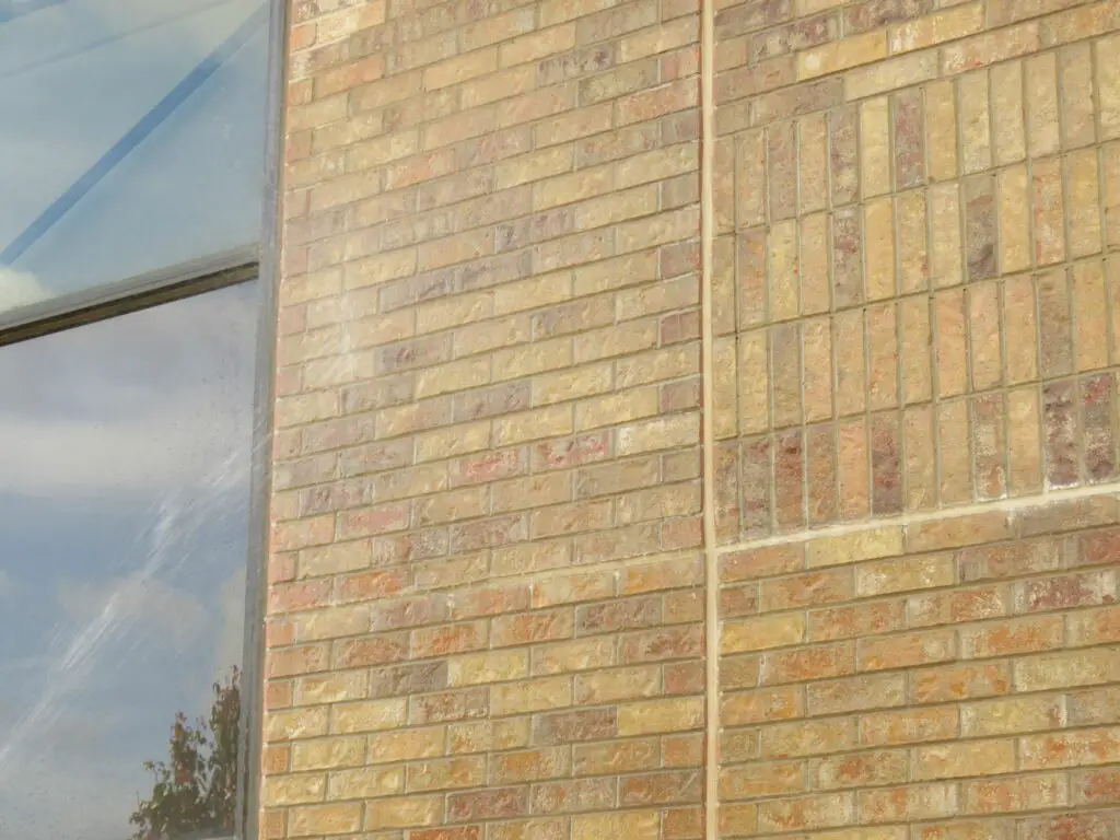 Sealant-filled expansion joints in the brick veneer on an office building exterior wall.