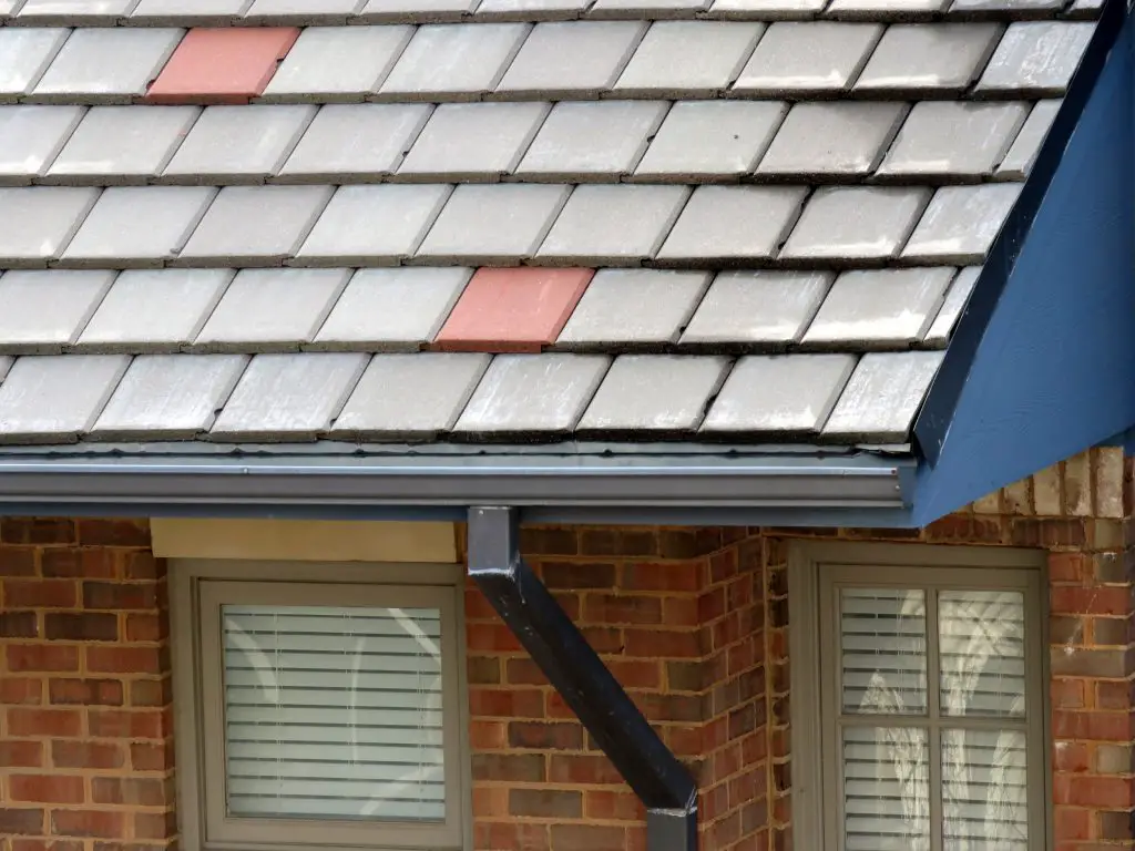 K-style gutter with downspout on a steep-slope roof.