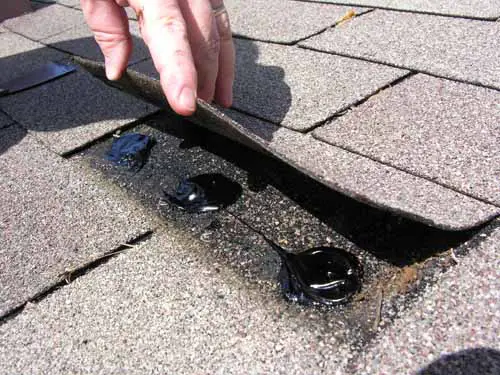Spot applications of roof cement under a shingle tab