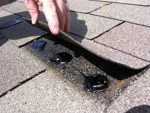 Spot applications of roof cement under a shingle tab.