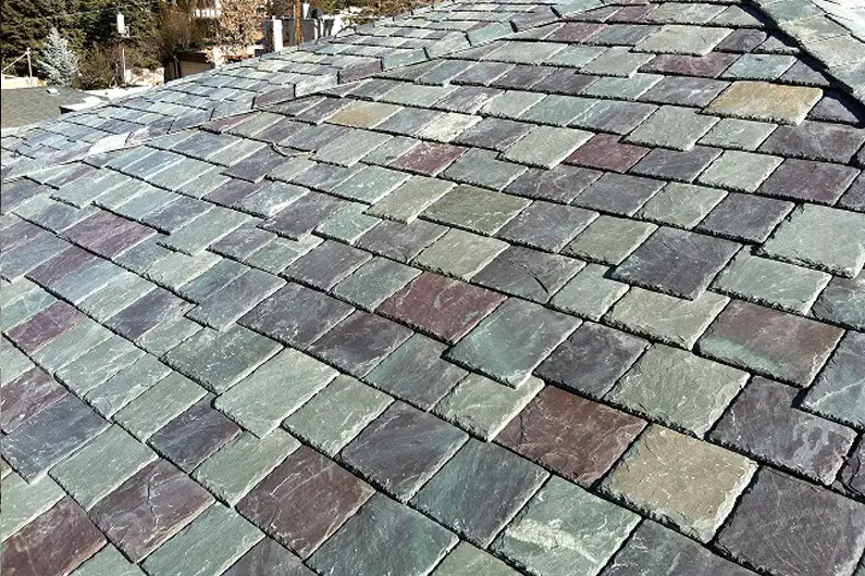 View of part of a hang-down random-width multi-colored slate roof. Fancy details like this can increase your slate roof cost.