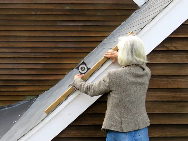 Measuring roof slope with a slope finder.