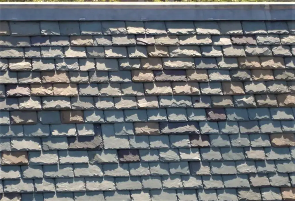 A multi-colored, heavy-textured slate roof with gray, green, red, and deep purple roofing slate colors