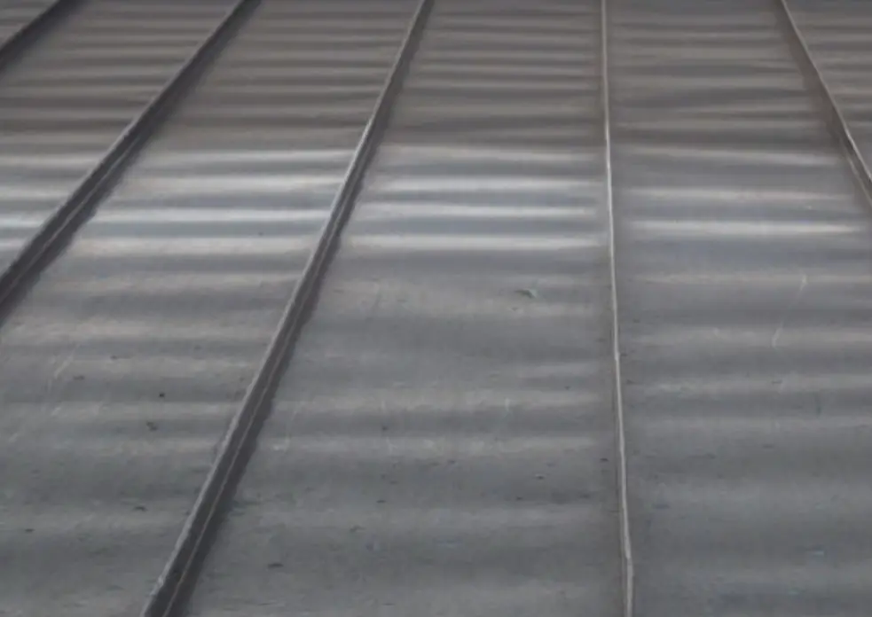 The appearance of oil canning in metal roof panels.