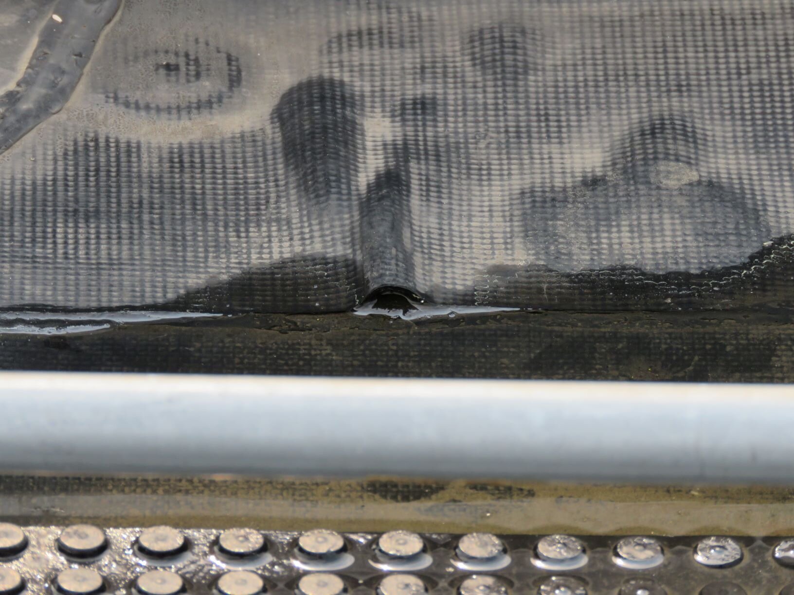 Reinforced EPDM: You can see the reinforcing scrim in this defect photo of a fishmouth.