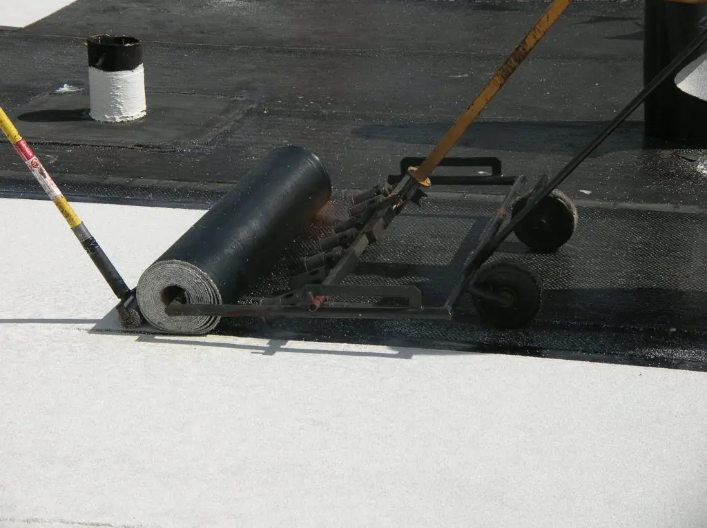 torch-applying a roll of modified bitumen roofing