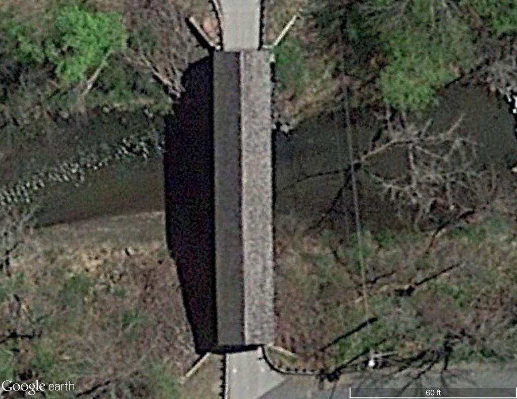 Satellite image of a covered bridge with a cedar shingle roof.