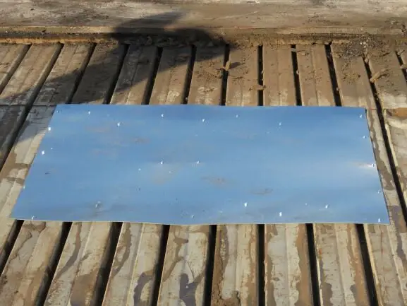 A piece of 24-gauge galvanized sheet steel used to patch a rusted area of steel roof deck.