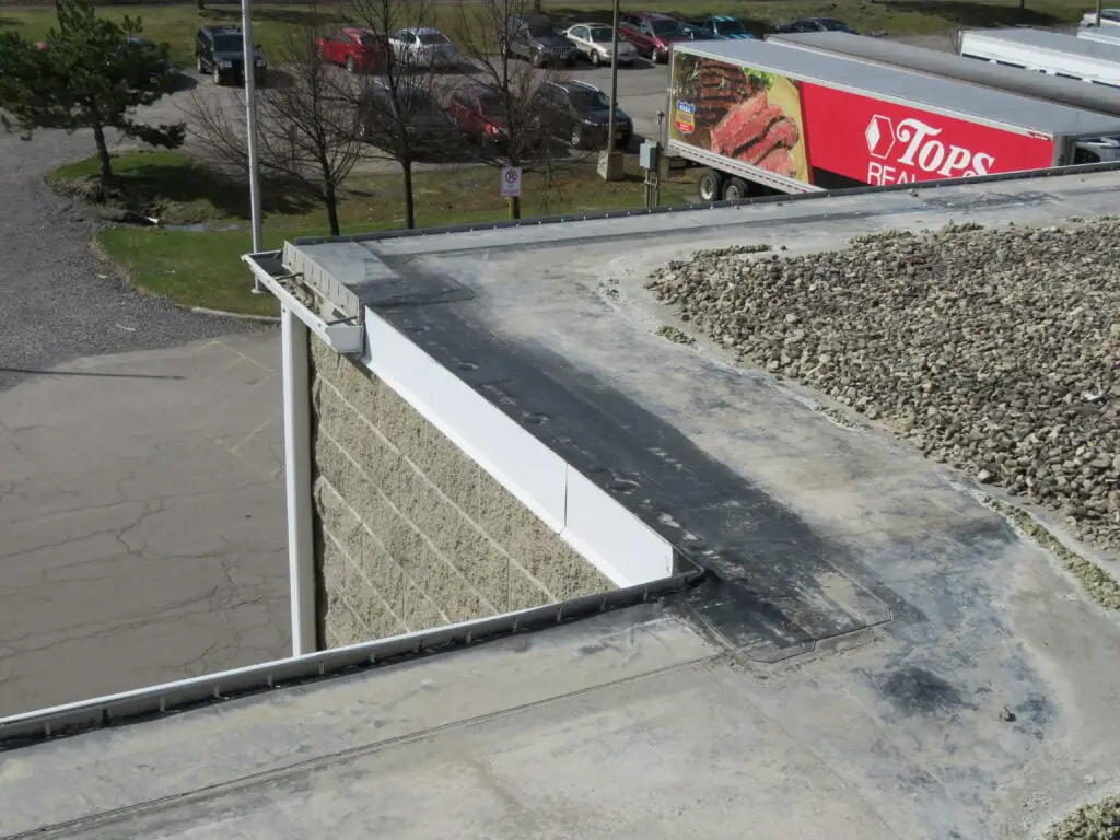 Slotted gravel stop edge metal on a ballasted EPDM roof.