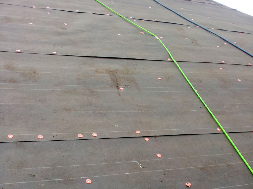 “Tar paper” roofing underlayment (asphalt-impregnated roofing felt) during the installation of an asphalt shingle roof.