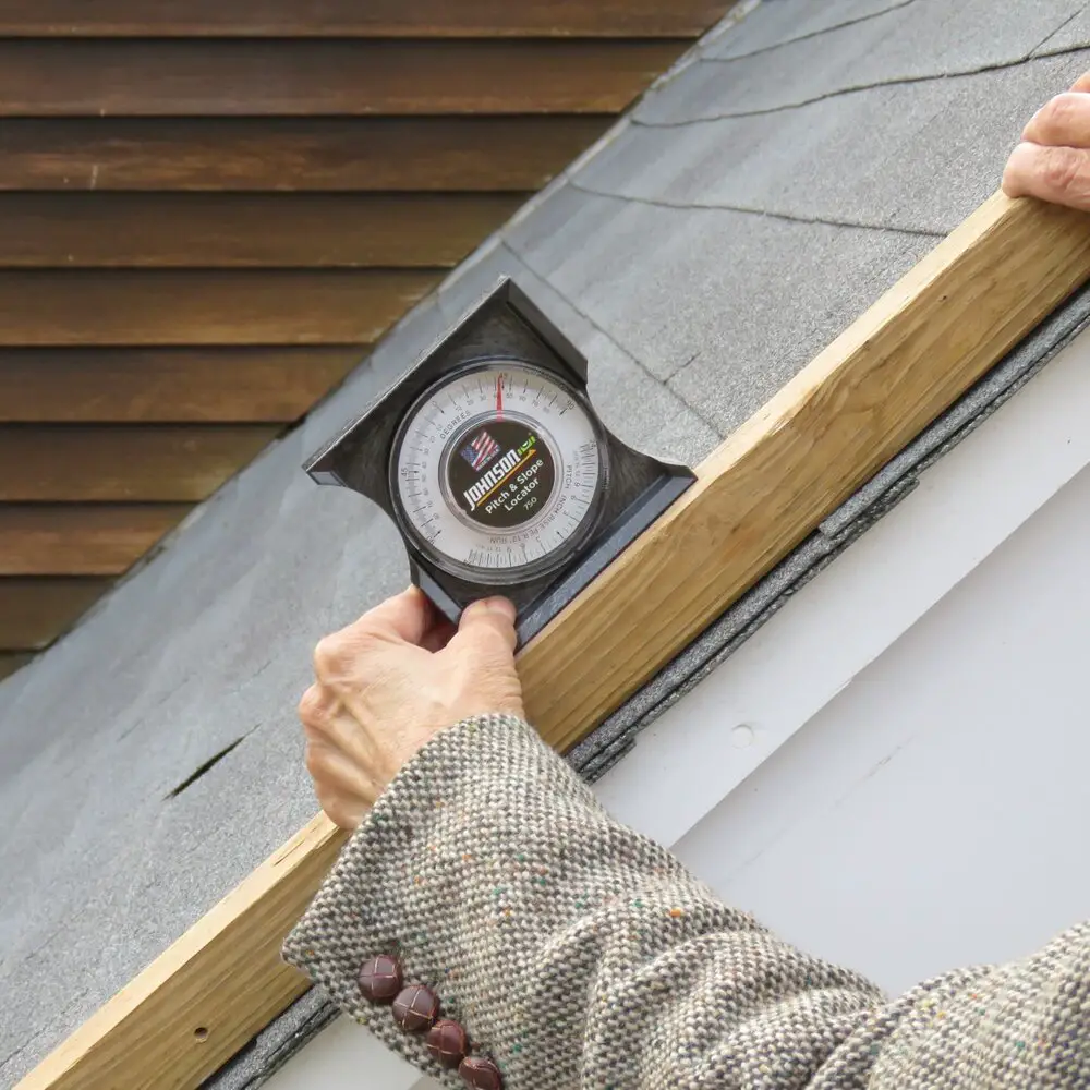 using a pitch finder tool to find the roof pitch, which is the first step to finding the roof pitch factor.