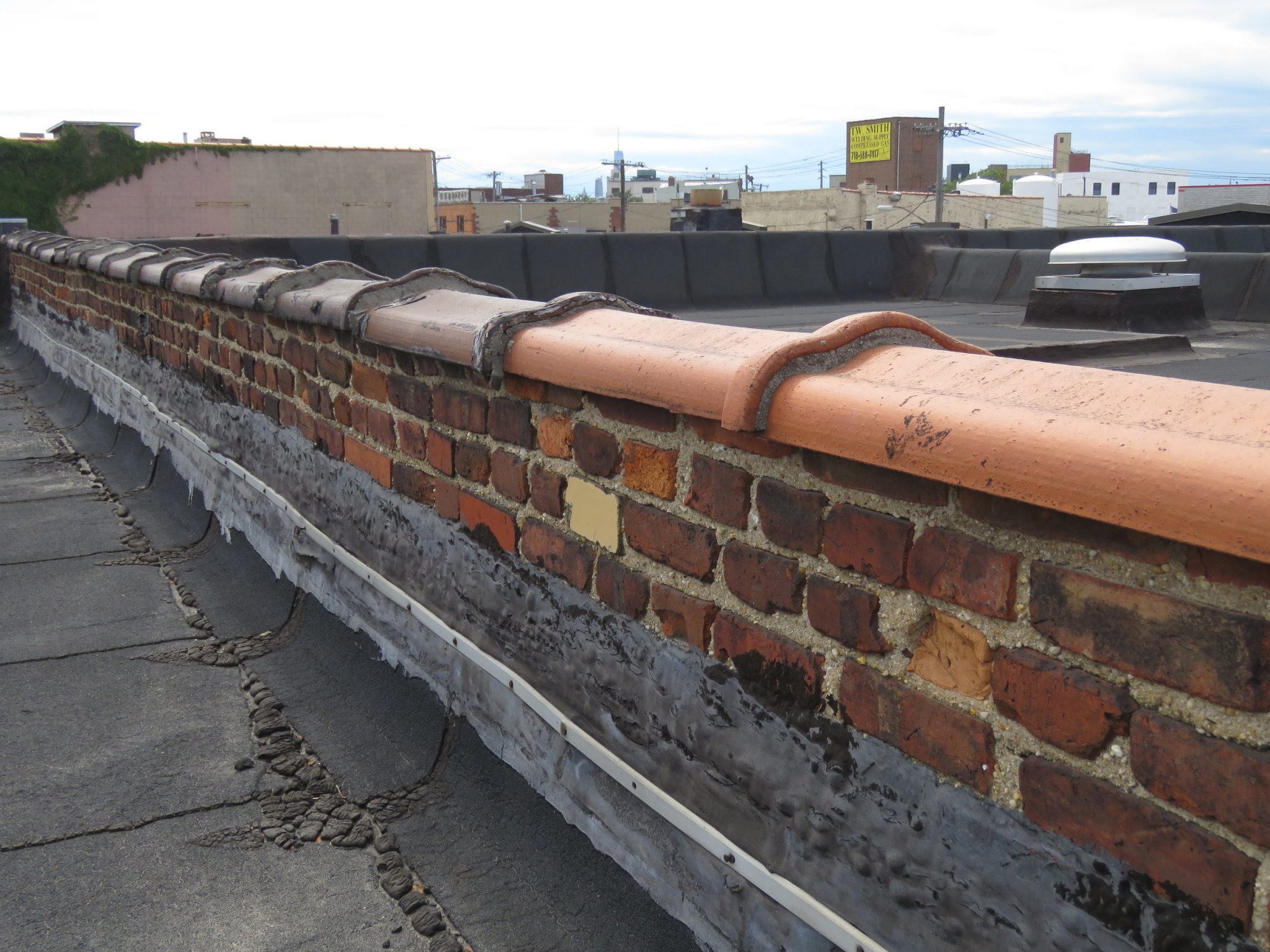 Camelback terra-cotta coping on a brick wall